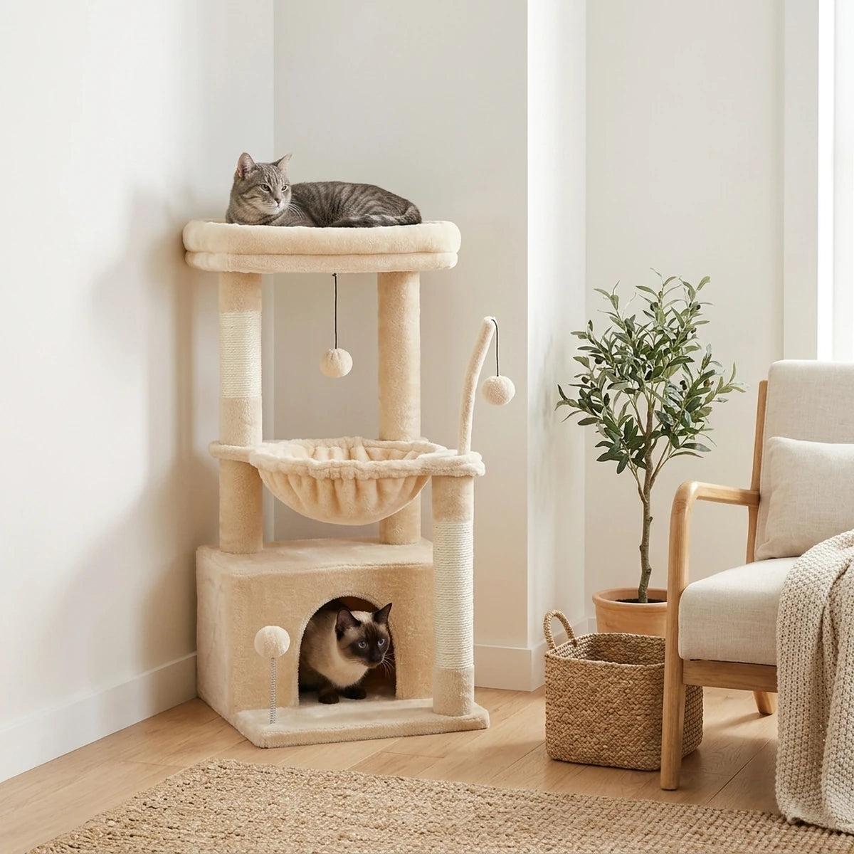 Arbre à chat Le Douillet beige dans l'angle d'un salon lumineux, chat tigré sur le perchoir et chat siamois dans la niche